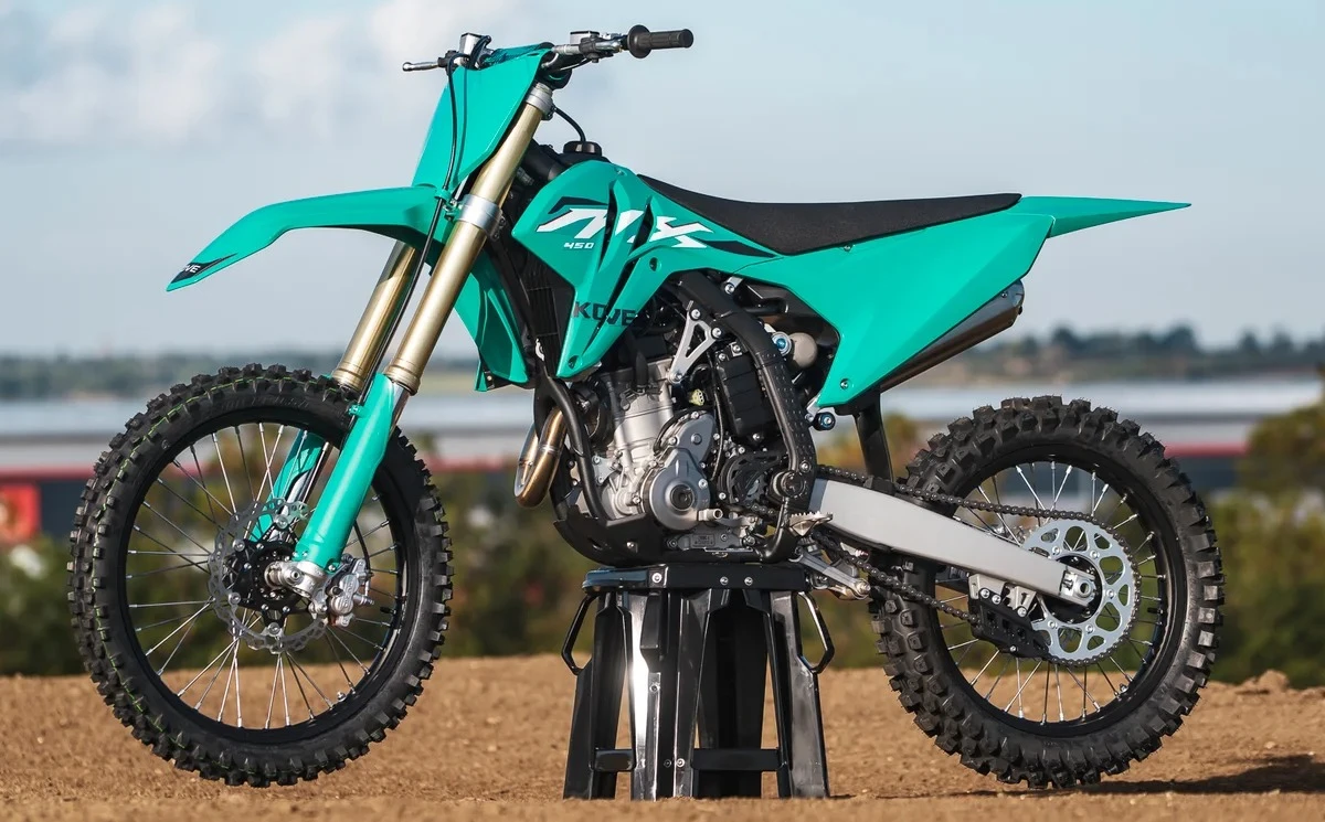 A green MX450 Cross R motorcycle on a workshop stand