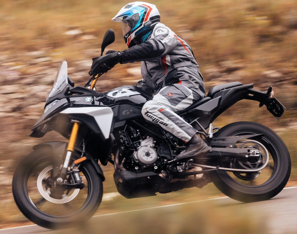 Une moto BMW F 450 GS noire et un motard avec des vetements typés aventure