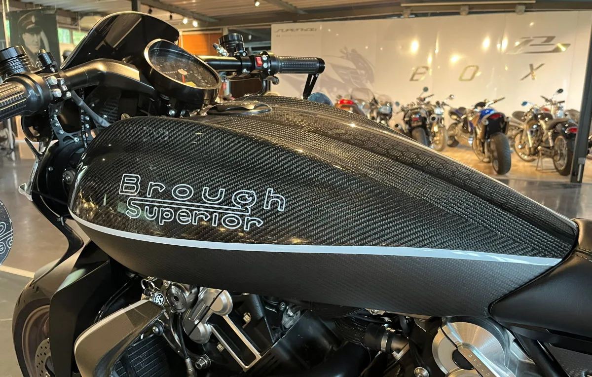 Un réservoir en carbone de Brough Superior Dagger S et des motos Boxer Design en arrière-plan