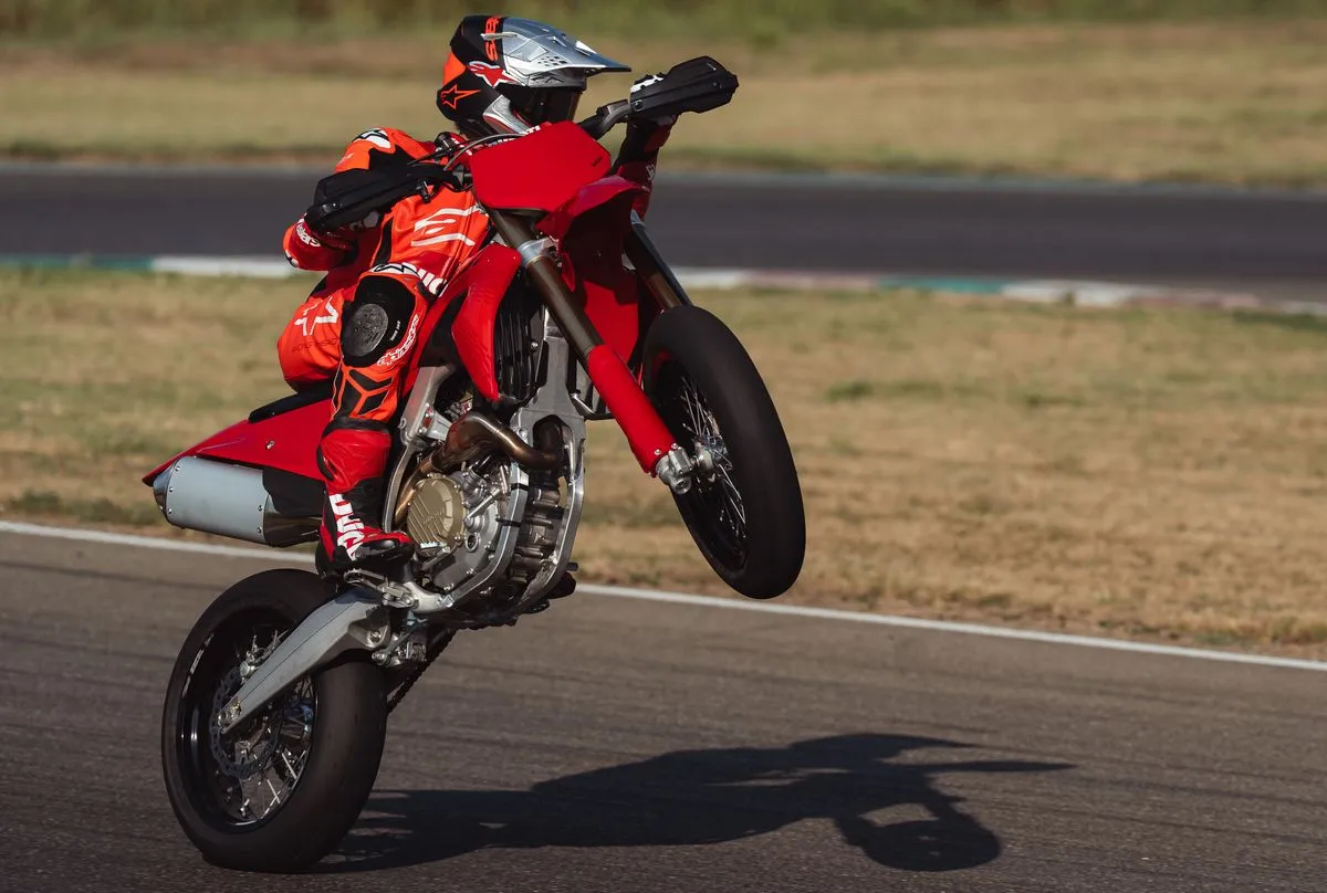 Une moto Ducati Desmo 450 SM rouge en wheelon,g sur un circuit