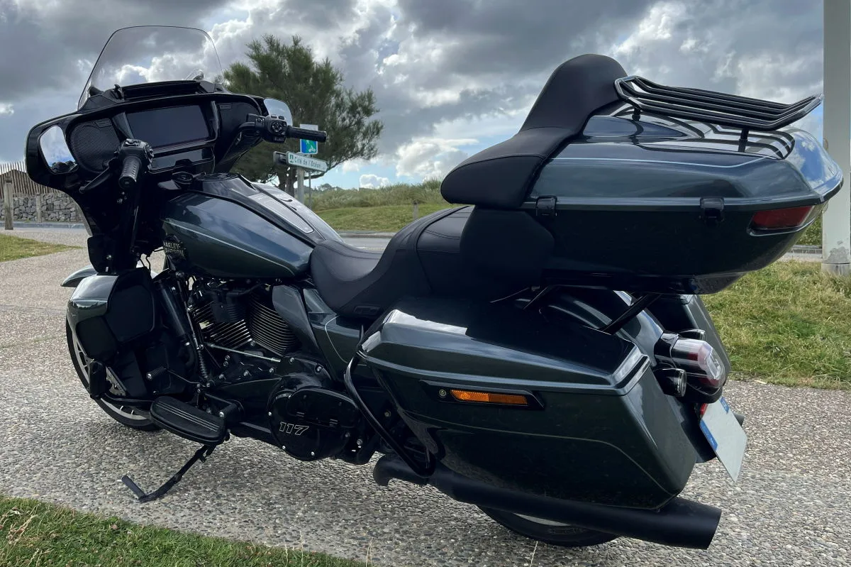 Une moto Harley-Davidson Street Glide Limited, de la verdure, un ciel nuageux