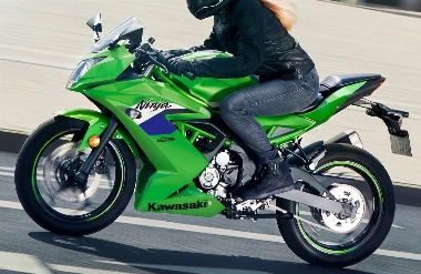 Une moto Kawasaki 125 Ninja verte de 2027 sur route