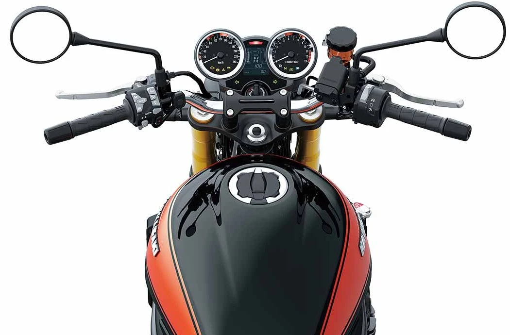 Le poste de conduite d'une Kawasaki Z 900 RS SE, avec un réservoir noir et des bandes oranges