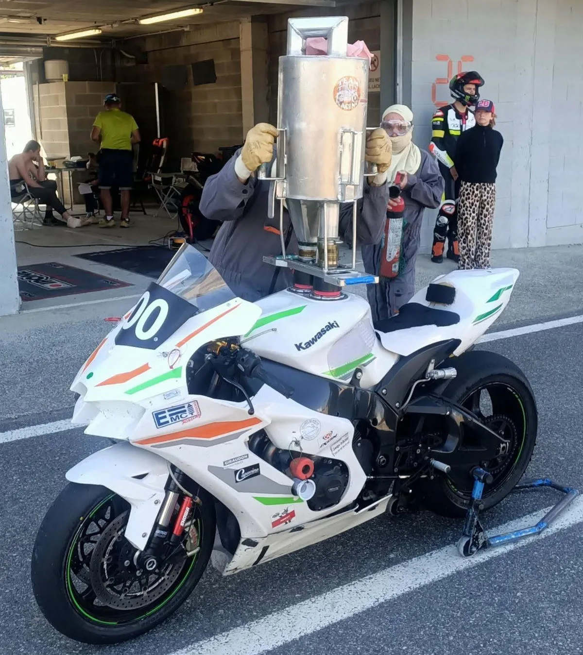 Une Kawasaki ZX-10R blanche, un derrick de remplissage d'essence