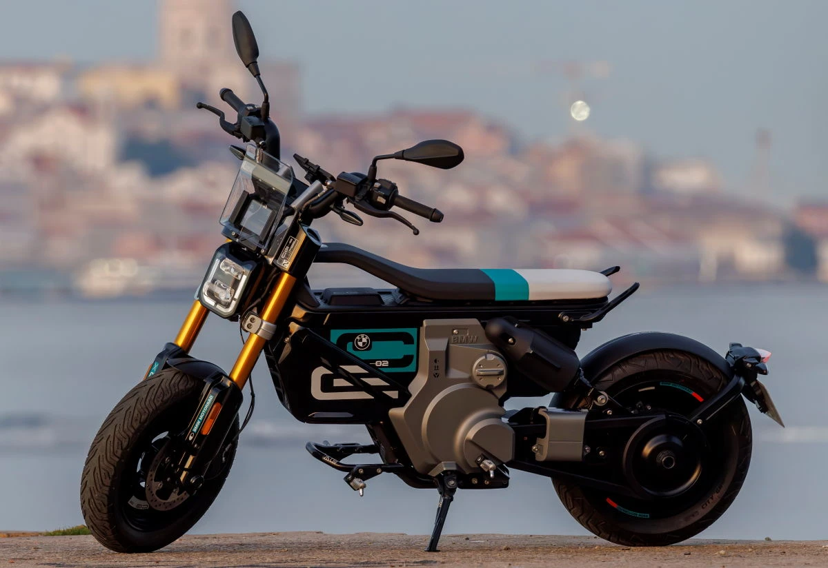 Un scooter BMW CE-02 devant un bord de mer flou