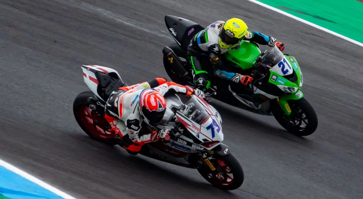 Une moto vert et une moto blanche et rouge sur circuit.