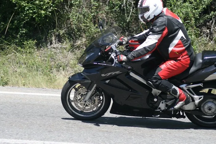 motocycliste assis sur sa moto sur une route de campagne