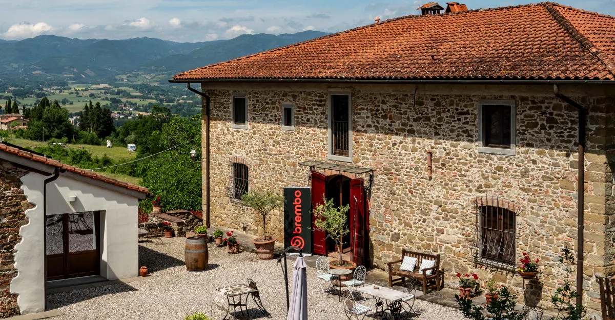 Une vieille maison en pierre, un paysage montagneux, une bannière Brembo
