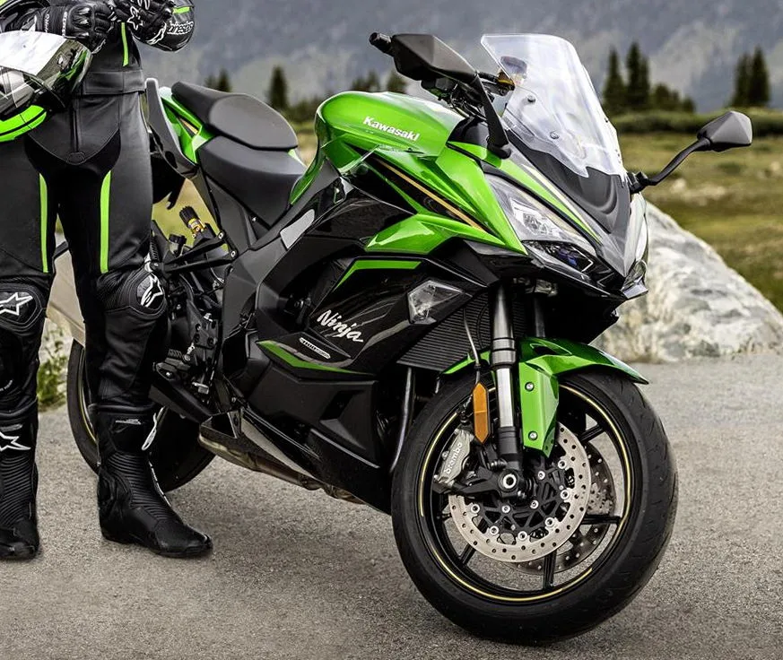 Kawasaki 1100 SX SE 2025 noire et verte avec son pilote devant les montagnes
