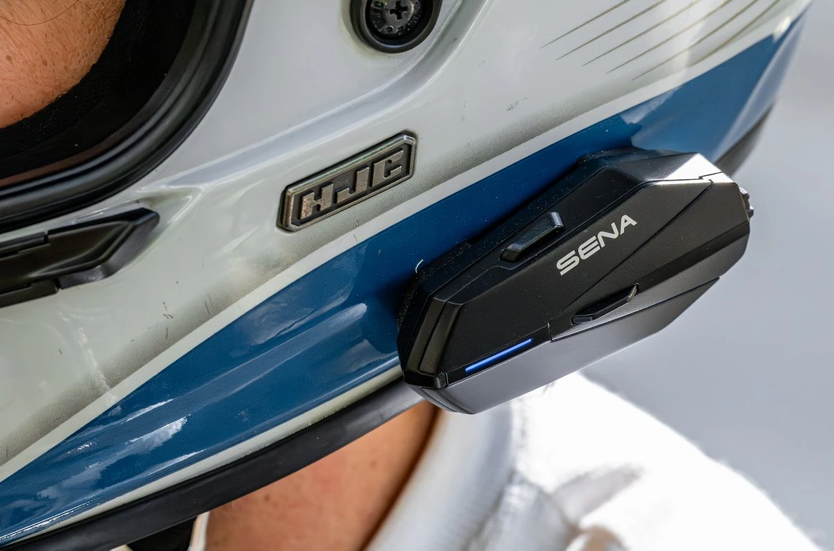 Un intercom Sena Apex et un casque de moto blanc avec une bande bleu basse