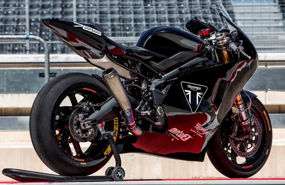 Une moto sportive noire avec le logo Triumph et des gradins