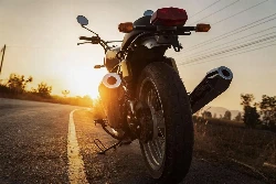 L'arrière d'une moto avec un couché de soleil en fond