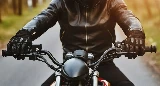 A motorcycle handlebar, gloves, and jacket