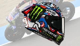 Un casque HJC Rpha 1 v2 en carbone avec le coloris Snow Diablo et une moto Yamaha M1 derrière