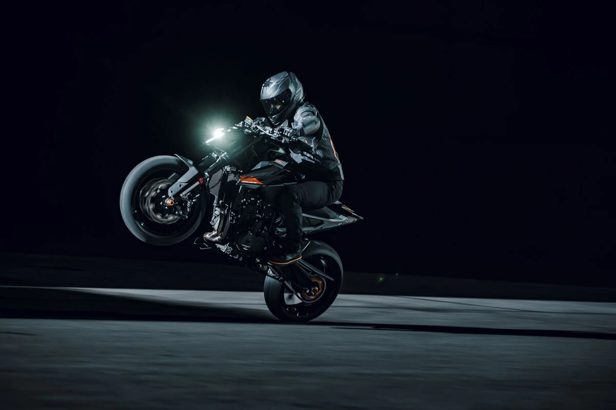 Pilote en action faisant un wheeling de nuit au guidon de la KTM 790 Duke 2027 noire — Photo : SAVAGE / KTM
