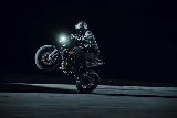 Pilote en action faisant un wheeling de nuit au guidon de la KTM 790 Duke 2027 noire — Photo : SAVAGE / KTM