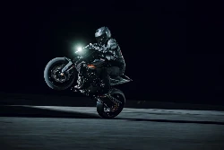 Pilote en action faisant un wheeling de nuit au guidon de la KTM 790 Duke 2027 noire — Photo : SAVAGE / KTM