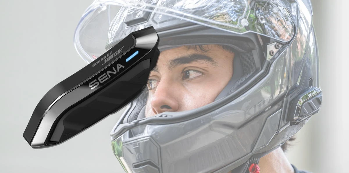 a motorcycle intercom and a motorcycle helmet with the visor open.