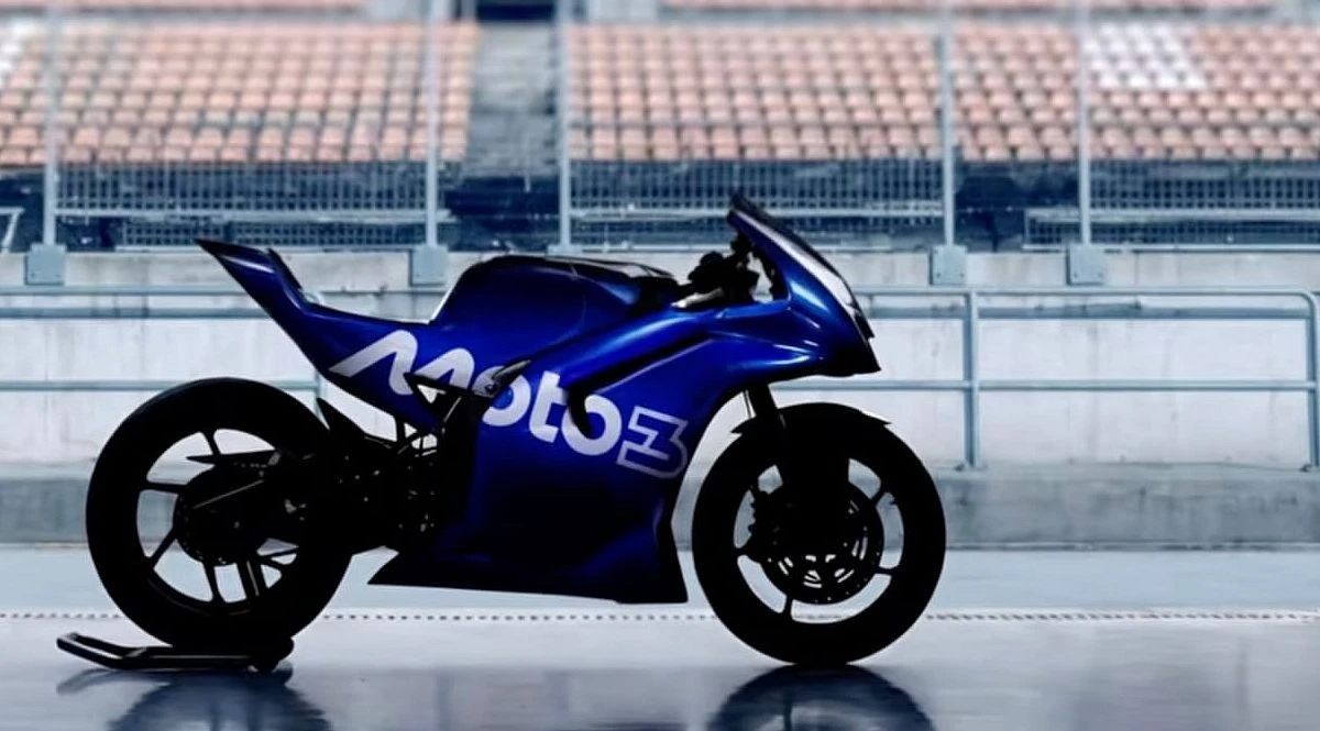Une silhouette de moto avec le texte Moto3, un arrière de stand et une tribune vide de spectateurs.