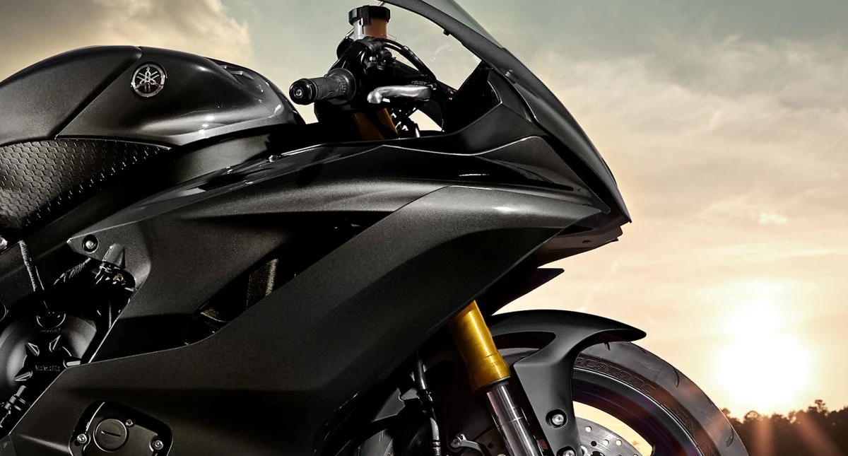 Una puesta de sol y la parte delantera de una moto Yamaha R6.