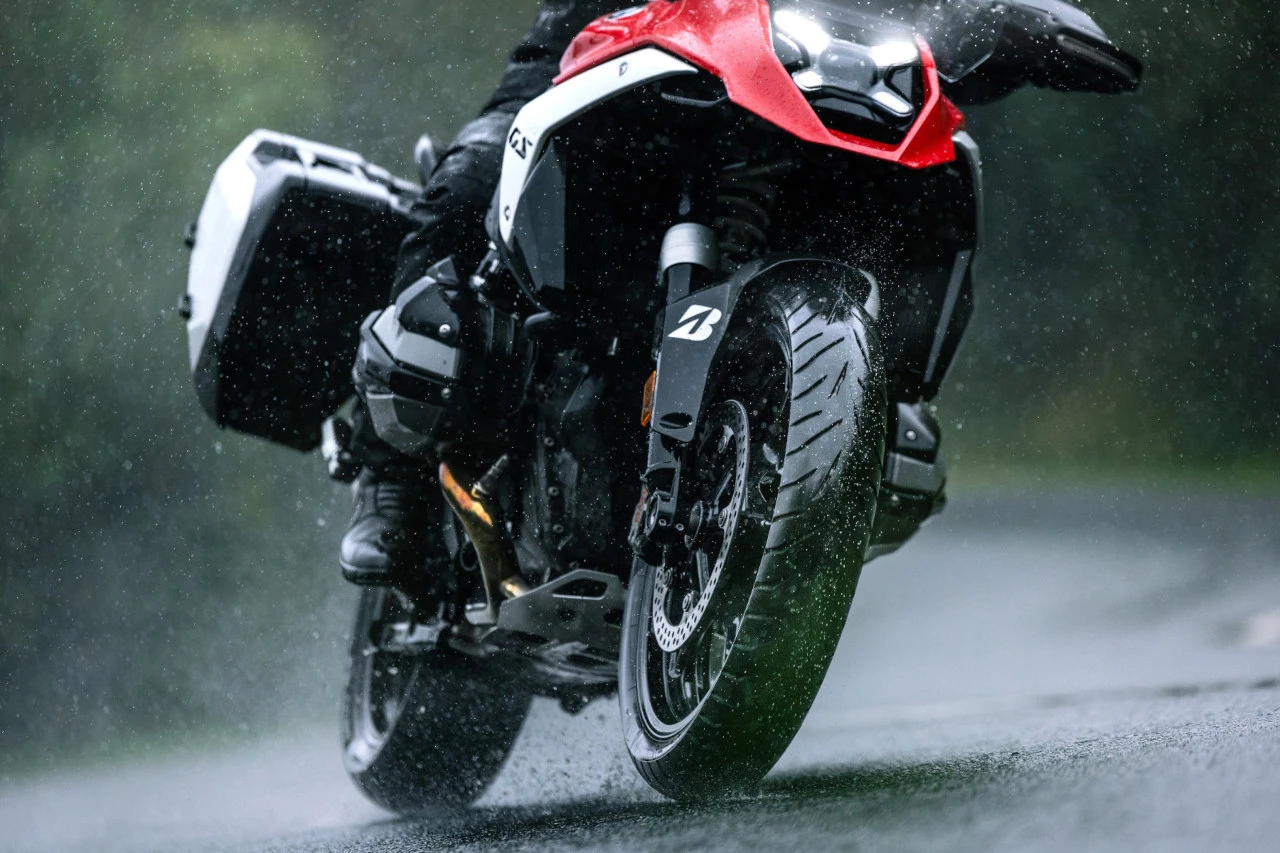 Neumáticos de trail Bridgestone Battlax Adventure A42 montados en una BMW GS roja bajo la lluvia