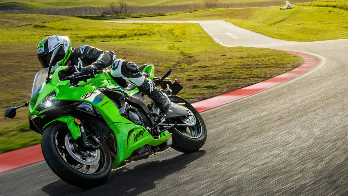 Une moto Kawasaki ZX-6R 636 verte, une route de circuit, de l'herbe.