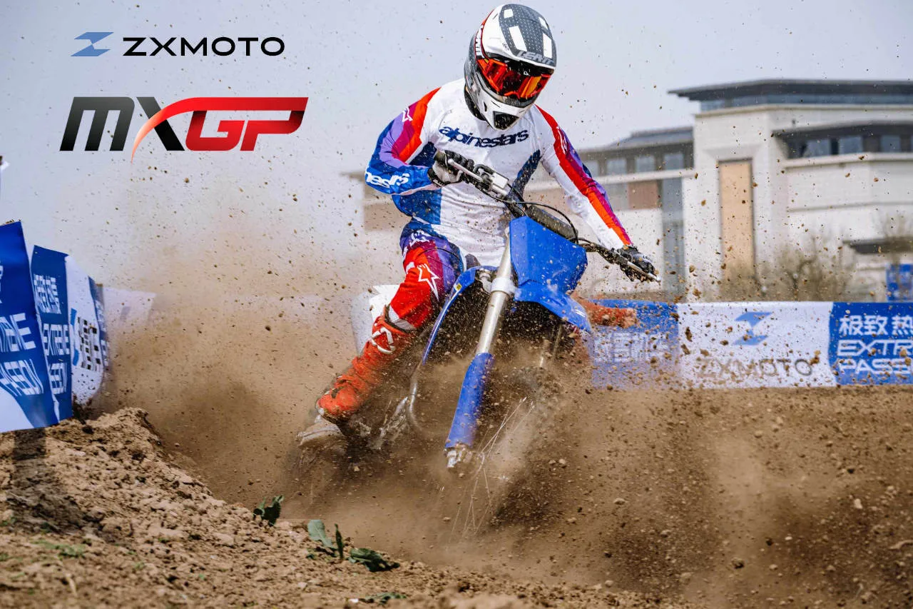 Une motocross de ZXmoto avec des projections de terre dans un virage