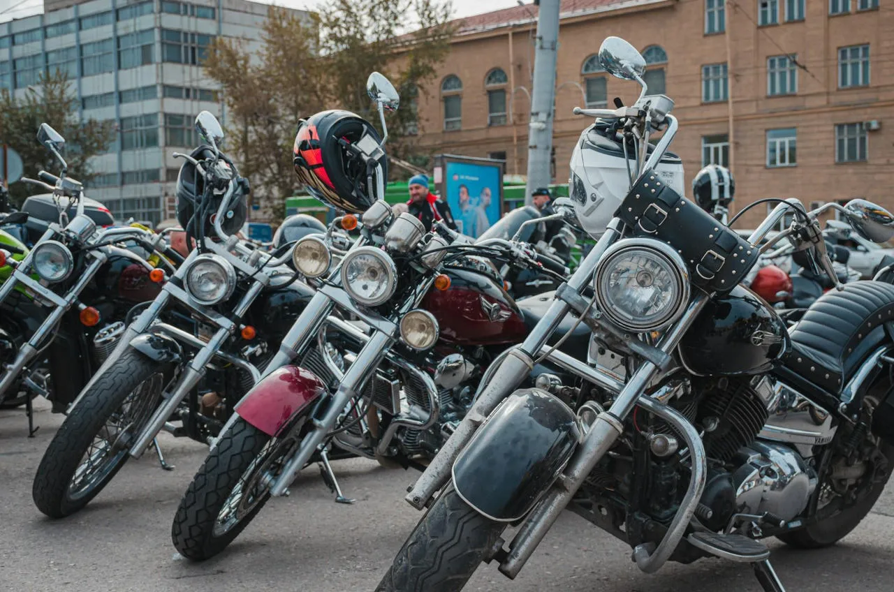 Des motos customs stationnées avec les casques de motards accrochés aux guidons