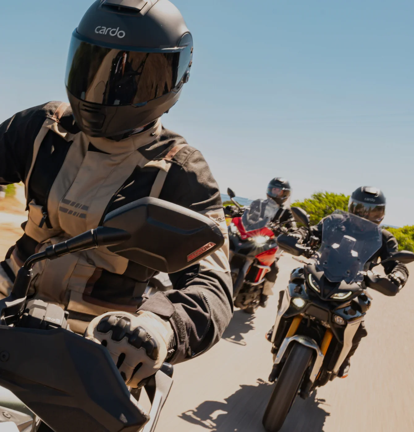 Trois motards avec le premier qui porte un casque Cardo GTS avec intercom intégré
