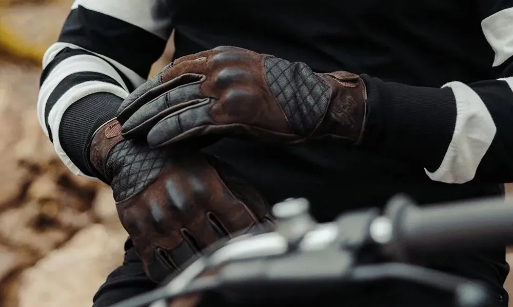 Des gants de moto en cuir et des manches de polo bleues et blanches