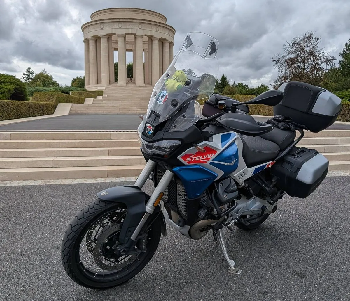 Une Moto-Guzzi 1000 Stelvio devant un bâtiment de type romain avec des colonnes