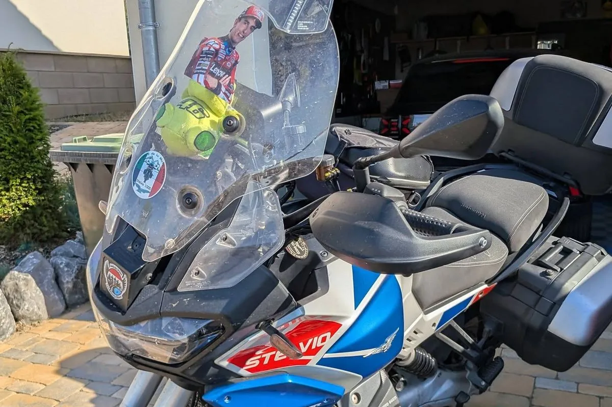 La partie avant d'une Moto-Guzzi 1000 Stelvio avec une peluche VR46 et le portrait de Marc Marquez