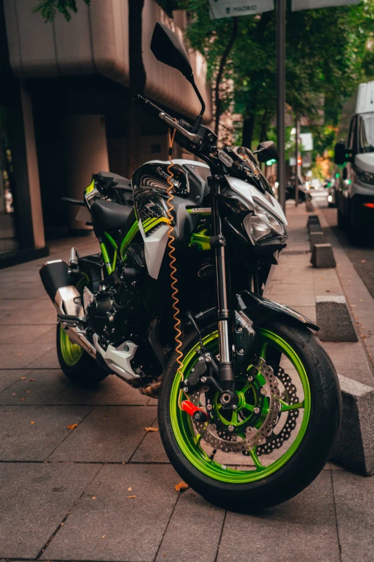 Un roadster Kawasaki avec un antivol rouge et jaune fixé sur la roue avant