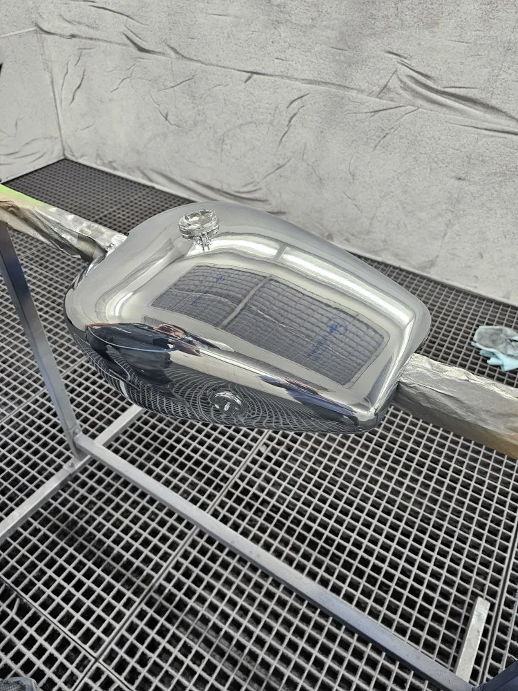 Le réservoir chromé d'une moto dans une salle de peinture