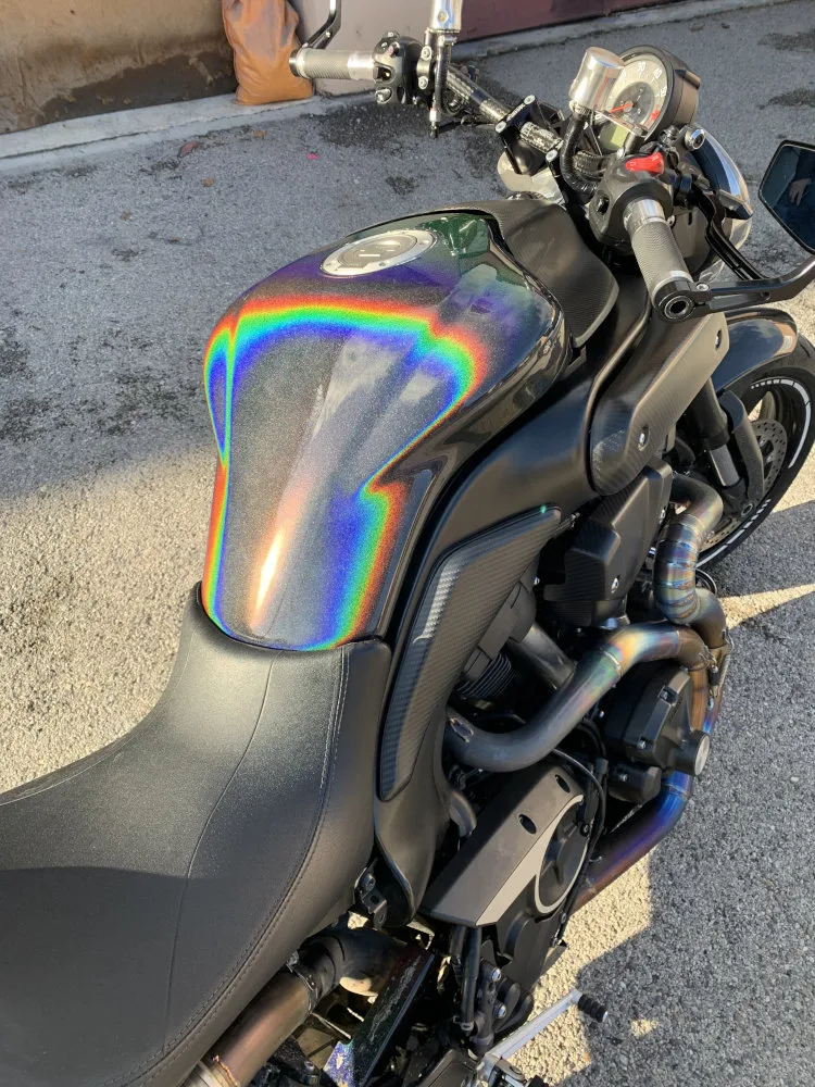 Peinture holographique sur le réservoir d'une moto, un arc-en-ciel se dessine sur le réservoir.