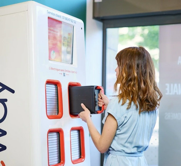 Jeune femme qui retire une recharge électrique d'une borne
