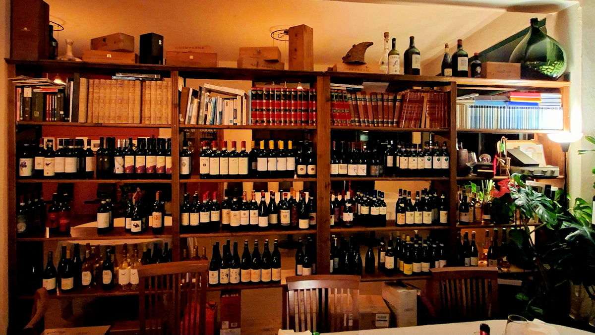 Une étagère avec des livres et des bouteilles de vin
